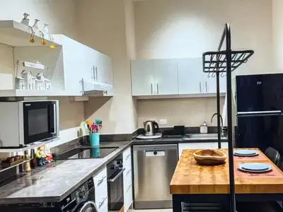 a kitchen with white cabinets and a black refrigerator at View and Location in Abu Tig Marina in Hurghada