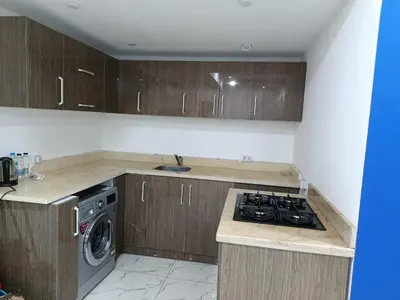 a kitchen with wooden cabinets and a stove top oven at Fanadir Bay in Hurghada