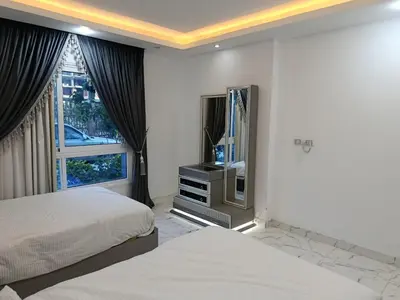 a bedroom with two beds and a tv and a window at Fanadir Bay in Hurghada