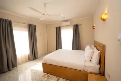 a bedroom with a bed with white sheets and pillows at Villa Ramses in Luxor