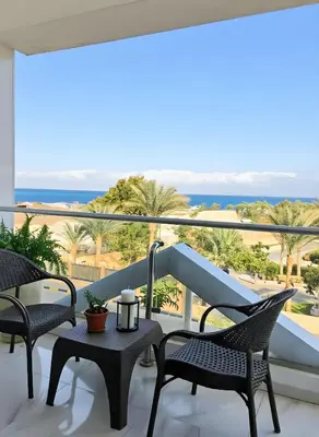 a balcony with chairs and a view of the ocean at Hurghada stylish Apartment on the beach in Hurghada