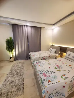 a bedroom with two beds and a potted plant at Mirage bay aquapark 772B in Hurghada