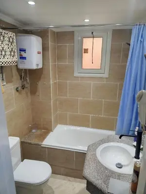 a bathroom with a tub and a toilet and a sink at Apartment with garden in sahl hasheesh in Hurghada