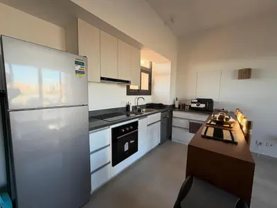 a kitchen with a large refrigerator and a sink at Fresh & Modern 2BR • Newly Furnished Kamaran in Hurghada