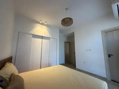 a white room with a bed and a closet at Fresh & Modern 2BR • Newly Furnished Kamaran in Hurghada