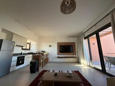a kitchen and living room with a table and a refrigerator at Fresh & Modern 2BR • Newly Furnished Kamaran in Hurghada
