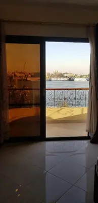 a door to a balcony with a view of the water at El BOB HOUSE in Luxor