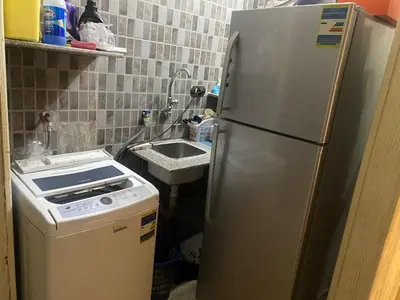 a kitchen with a refrigerator and a sink at فيلا المدينة البعيدة in Naj‘ al Maḩaţţah