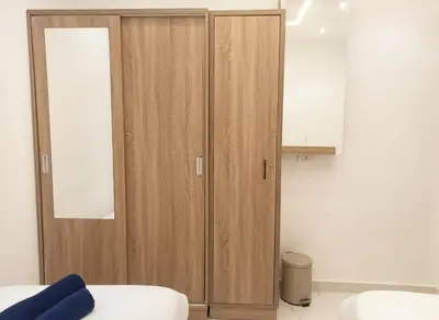 a wooden cabinet in a room with a white wall at Hurghada luxury apartment sea view in Hurghada