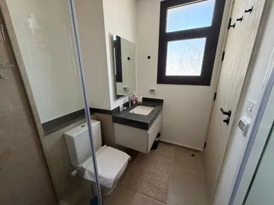 a bathroom with a toilet and a sink and a shower at Bright Kamaran 2BR | Lofty Ceilings & Pool Access in Hurghada