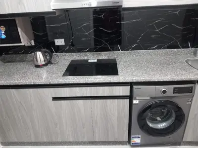 a kitchen counter with a washing machine in a kitchen at شقة اللؤلؤة in Hurghada