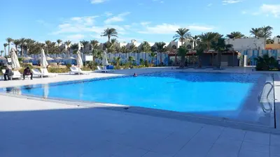 a large pool with blue water in a resort at Naseem Home in Hurghada