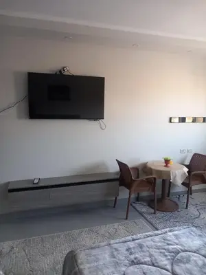 a living room with a tv on a white wall at Naseem Home in Hurghada
