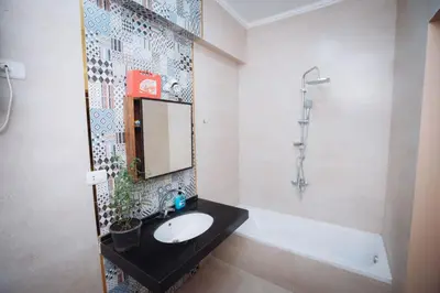 a bathroom with a sink and a mirror and a tub at Karnak Temple Inn in Luxor