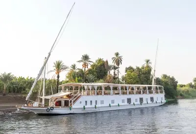 a large white boat is docked on the water at Miss Fatima Dahabiya-Nile Cruise 4 night sailing-Includes English speaking Guide and site seeing -All inclusive excluding alcoholic beverages in Luxor
