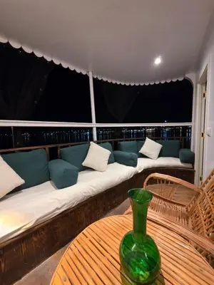 a room with a couch and a table with a vase on it at Miss Fatima Dahabiya-Nile Cruise 4 night sailing-Includes English speaking Guide and site seeing -All inclusive excluding alcoholic beverages in Luxor
