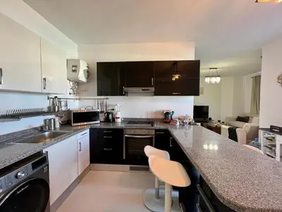 a kitchen with black and white cabinets and a counter at 4BR Penthouse, Lagoon View, Swanlake El Gouna in Hurghada