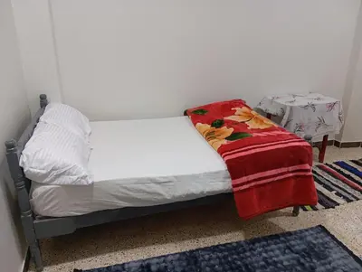 a small bed in a room with a blanket on it at Rafe Guest House in Luxor