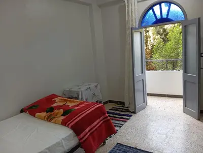 a bedroom with a bed and a large window at Rafe Guest House in Luxor