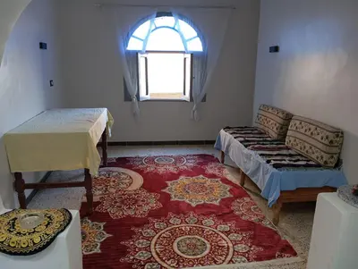 a room with a couch and a window and a rug at Rafe Guest House in Luxor