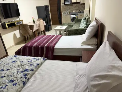 two beds in a room with a living room at Tiba Golden Beach Hurghada in Hurghada