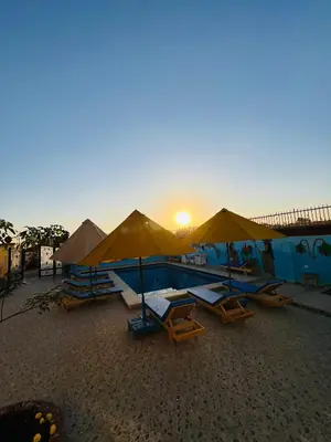 a group of chairs and umbrellas on a beach at Horus Golden Luxor in Luxor