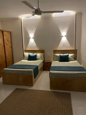 a bedroom with two beds and a ceiling fan at Luxe Nest Luxor Serviced Apartments 302 in Luxor