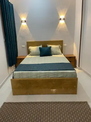 a bedroom with a large wooden bed with blue pillows at Luxe Nest Luxor Serviced Apartments 302 in Luxor