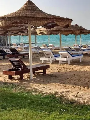 a group of chairs and umbrellas on a beach at Seaview Classy 2Bedroom Suite with beach access in Hurghada