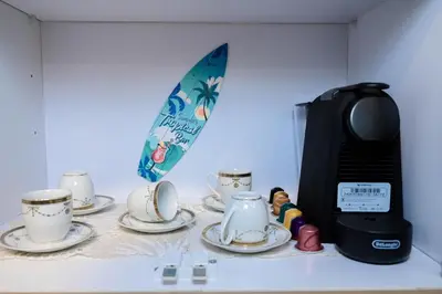 a table with cups and a coffee maker and a surfboard at 4,5 Zimmer Kiteapartment Selena Bay in Hurghada