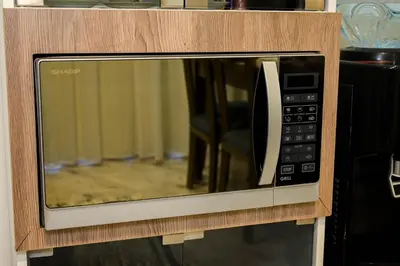a microwave oven with a wooden frame and a drawer at 4,5 Zimmer Kiteapartment Selena Bay in Hurghada