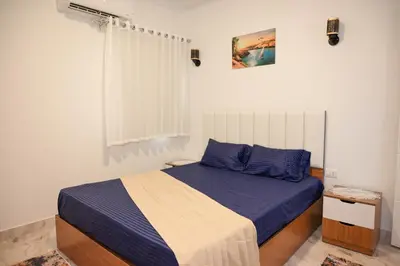 a bedroom with a bed with blue sheets and a window at 4,5 Zimmer Kiteapartment Selena Bay in Hurghada