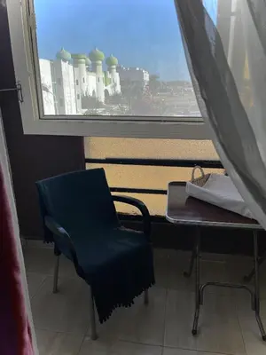 a desk and a chair in a room with a window at Studio Mirage Bay in Hurghada