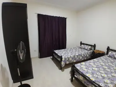 a bedroom with two beds and a dresser in it at Fayrouz Compound in Hurghada