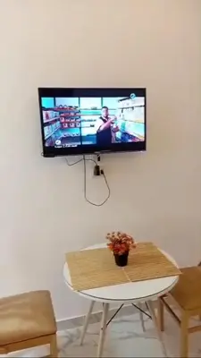 a flat screen tv hanging on a wall with a table at La bella resort touristic walkway hurghada in Hurghada