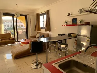 a kitchen and living room with a table and a refrigerator at Sea View luxury chalet in Hurghada