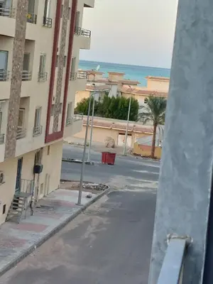 an empty street in front of a building with the ocean at Solitaire in Hurghada