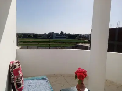 a vase with a flower sitting on a balcony at Bait el gabal in Al Aqālitah