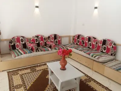 a living room with a long couch and a table at Bait el gabal in Al Aqālitah