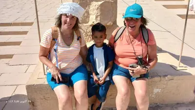 two women and a little boy sitting on a curb at The authentic Egyptian house in ‘Ezbet Abu Ḥabashi