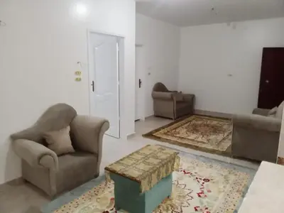 a living room with two chairs and a coffee table at Cozy 2-Bedroom Apartment Ramla, West Bank, Luxor in Luxor