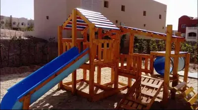 a wooden play set with a blue slide at The Best House in Makadi in Hurghada