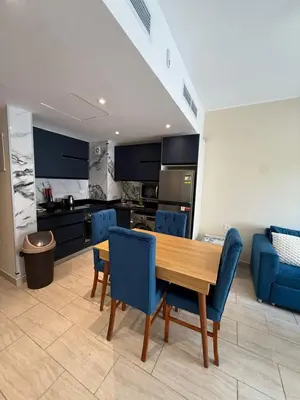 a kitchen with a wooden table and blue chairs at Casa Bonita 2307 in Hurghada