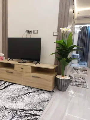 a living room with a television on a wooden entertainment center at سولتير in Hurghada