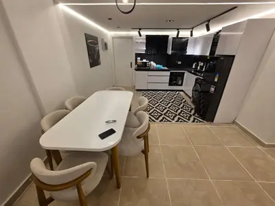 a dining room with a white table and chairs at Cozy Fully Furnished Apartment in Hurghada