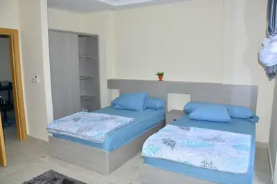 two beds with blue pillows in a room at Mirage Bay Resort Aquapark Cap Ahmed Suite in Hurghada
