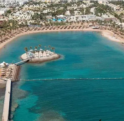 an aerial view of a beach with chairs and umbrellas at Mirage Bay Resort Aquapark Cap Ahmed Suite in Hurghada