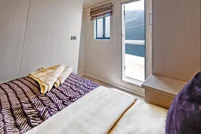 a small bedroom with a bed and a window at Yacht Aml-Hayaty in Hurghada