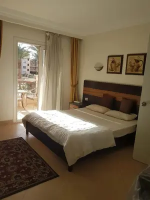 a bedroom with a large bed and a balcony at Sunset Barrel in Hurghada