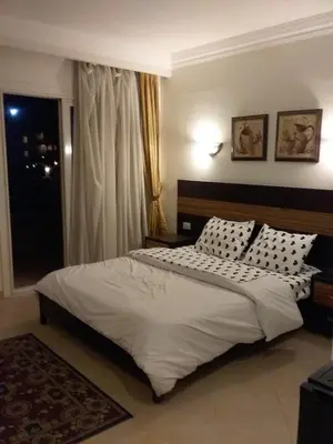a bedroom with a bed with white sheets and pillows at Sunset Barrel in Hurghada